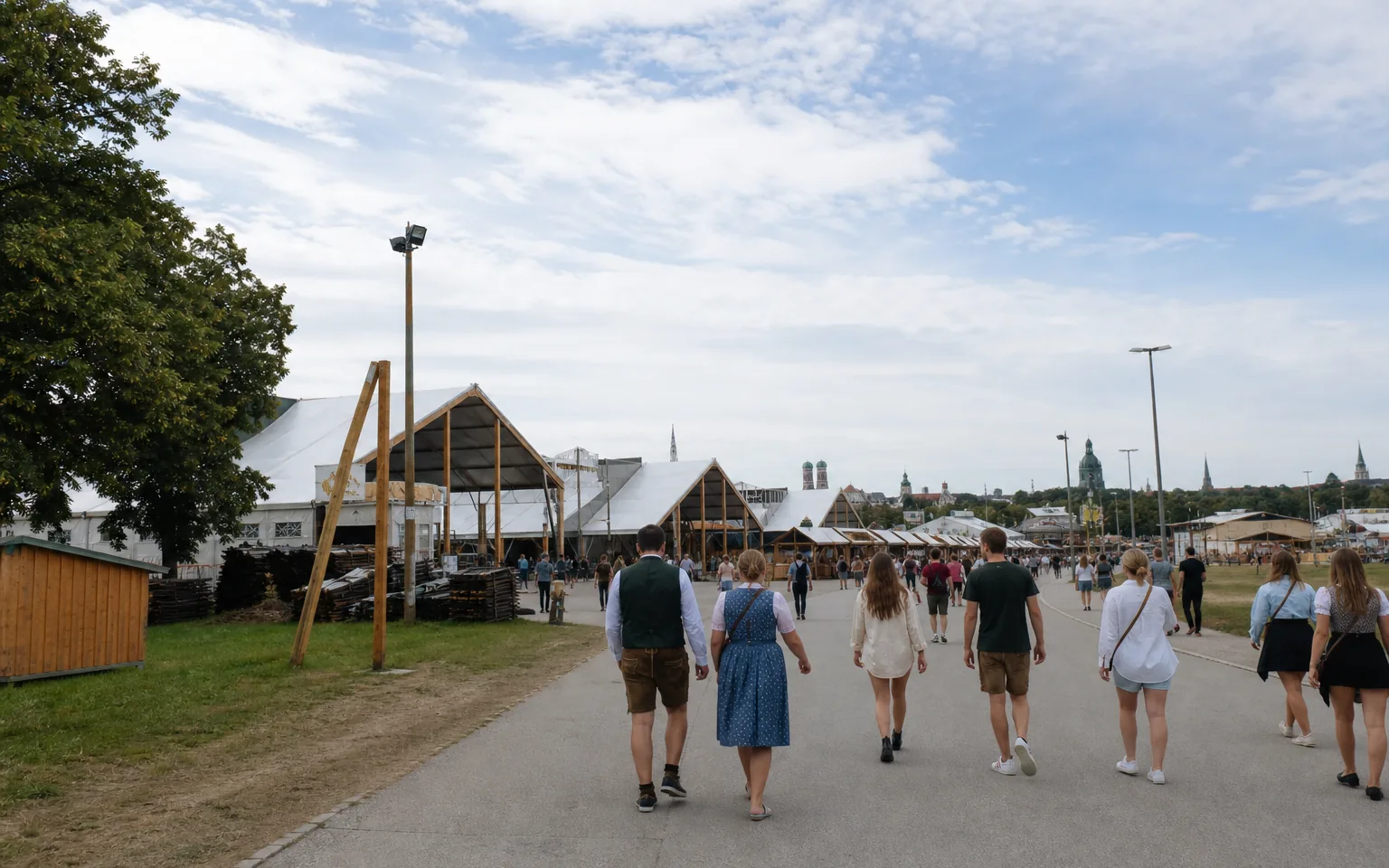 Besucherweg auf der Theresienwiese mit Festzeltdächern in München bei hellem Tageslicht